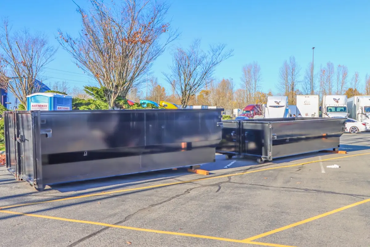 Professional dumpster rental service with roll-off container on residential driveway in Audubon